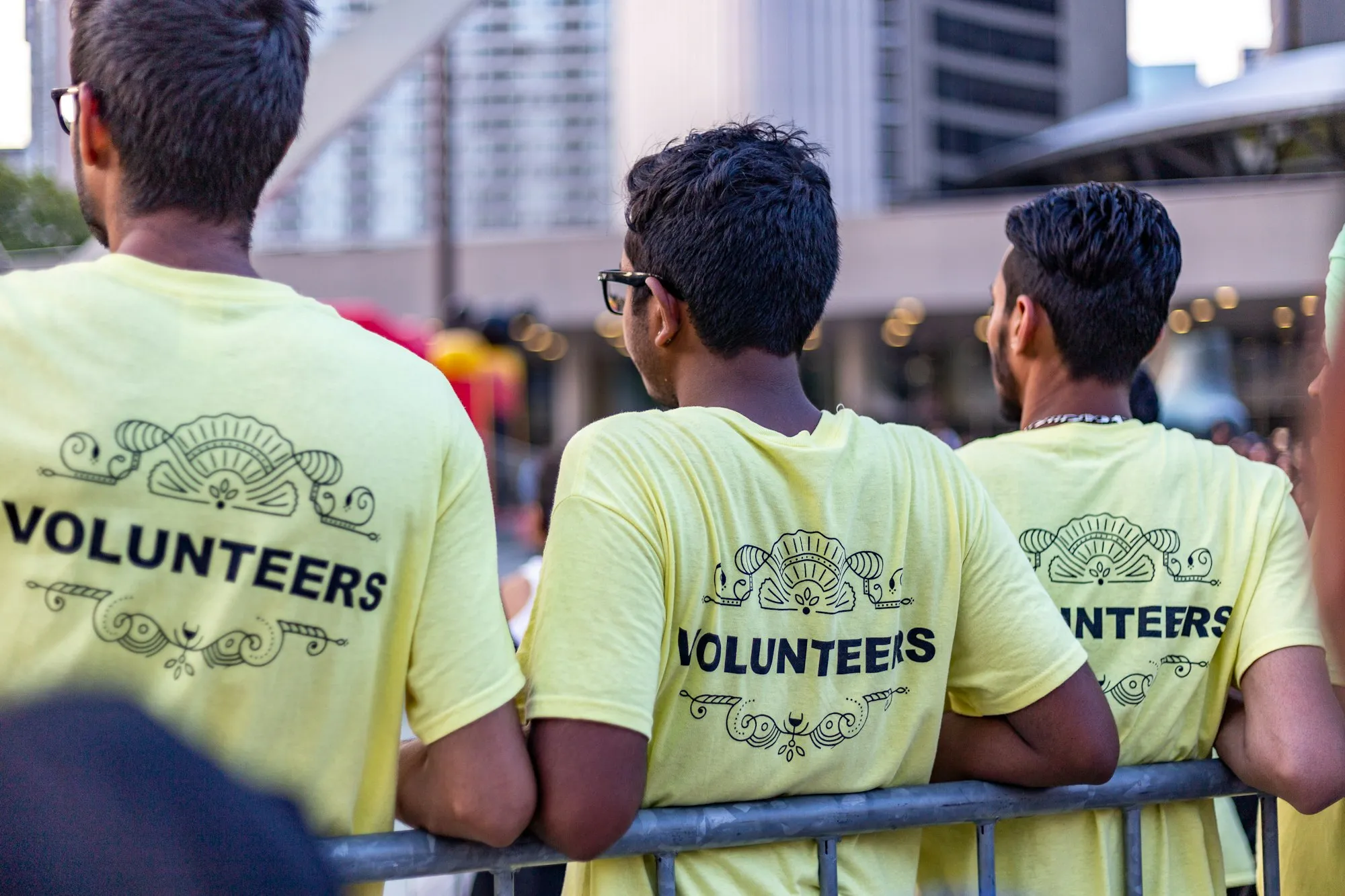 Three volunteers in matching yellow Volunteers T-shirts